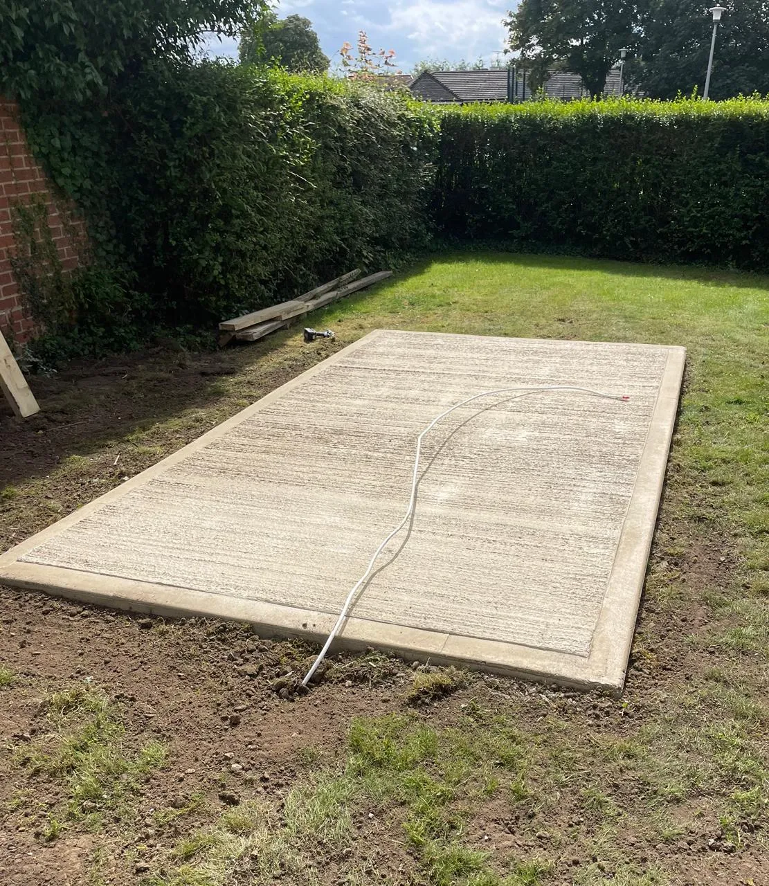 A concrete slab laying in the middle of a garden.