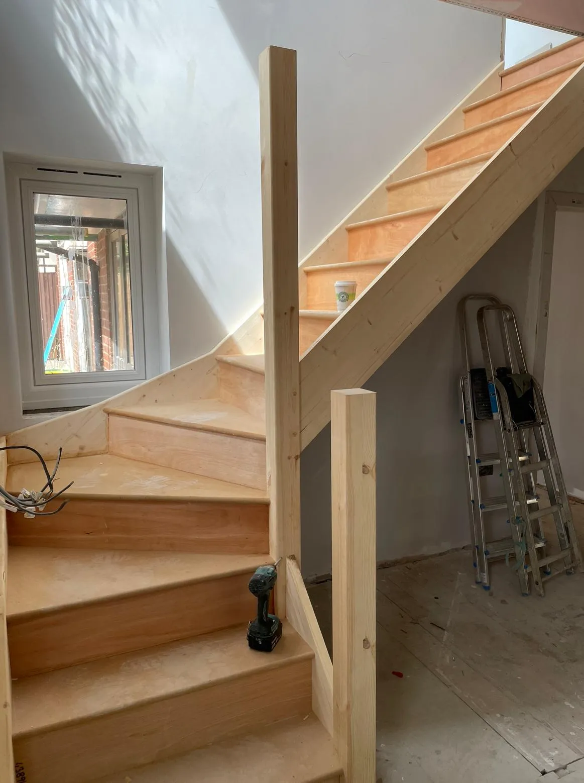 A wooden stair case in a home under construction.